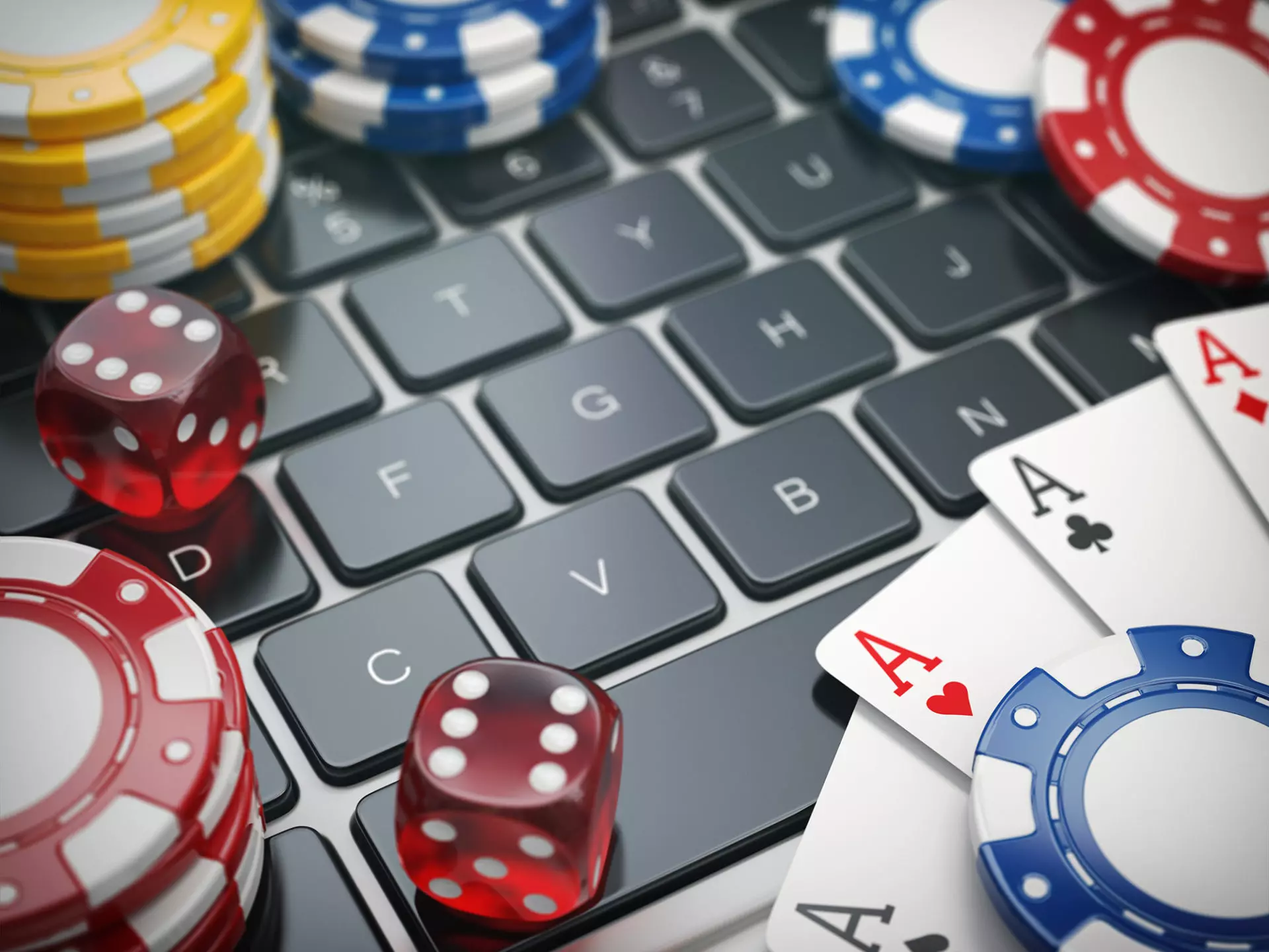 A picture on casino coins and dice on top of a laptop keyboard